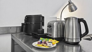 A kitchenette with a coffee maker, toaster, kettle, and a plate with food items. - Central 2 Bed Apartment Near Melbourne CBD (Melbourne)