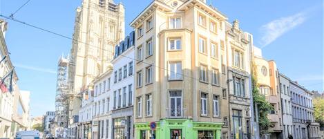 A multi-story building with a green storefront labeled 'DELI BOX' on the ground floor.