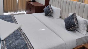 Ein Hotelzimmer mit einem Bett, einem Schreibtisch und zwei gerahmten Bildern an der Wand.