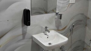 Ein Badezimmer mit einem weißen Waschbecken, einem Spiegel und einer Dusche.