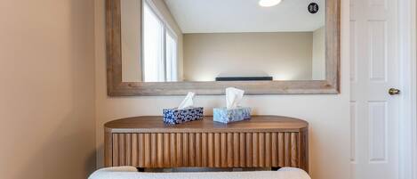 A wooden console table with two tissue boxes and a mirror above it.