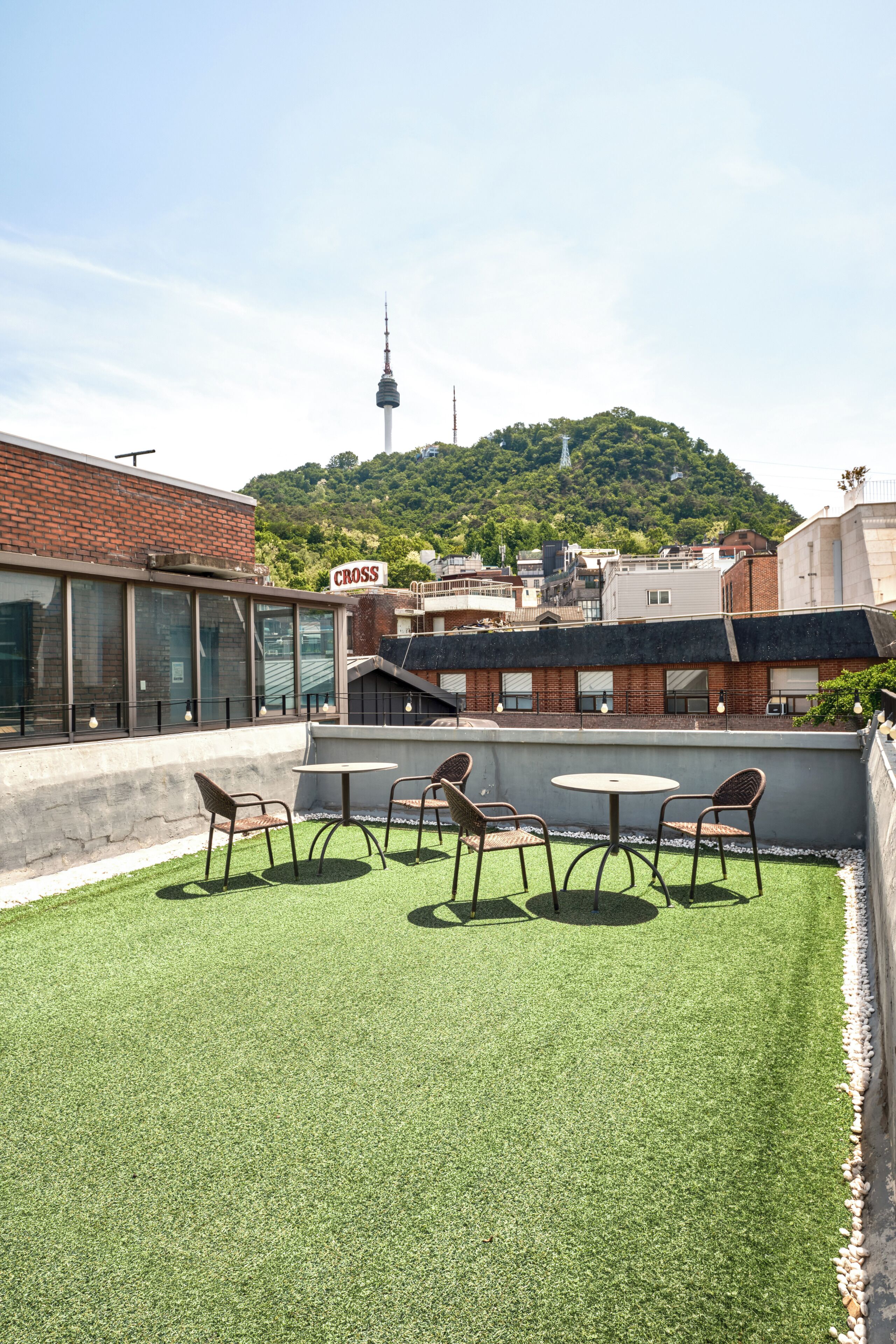 Une terrasse sur le toit, avec du gazon synthétique, une table et des chaises.