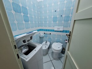 Ein kleines Badezimmer mit Toilette, Bidet und Waschbecken.