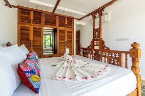 Une chambre d’hôtel avec un lit, une tête de lit en bois et une grande fenêtre.