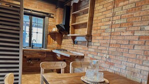 Una cocina rústica con muebles de madera, pared de ladrillo y ventana.