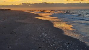 A beach with a sunset, waves, and a clear sky. - Welcome to Hidden Oasis, your dog-friendly home away from home in Sanibel! (Sanibel)