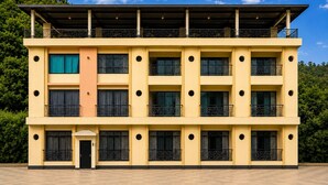 A multi-story building with balconies, a flat roof, and a checkered floor. - Charming 1-bedroom apartment in the heart of Ruighar (Ruighar)