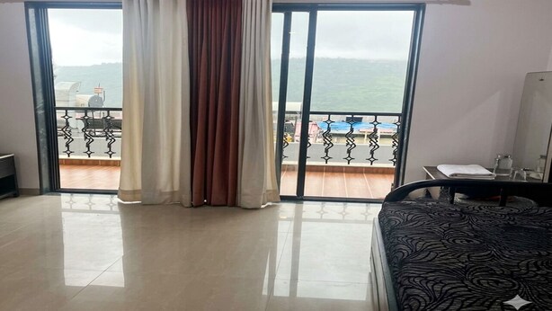 A hotel room with a balcony, a bed, a table, and a chair. - Charming 1-bedroom apartment in the heart of Ruighar (Ruighar)