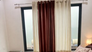 A bedroom with a bed, curtains, a window, a nightstand, and a lamp. - Charming 1-bedroom apartment in the heart of Ruighar (Ruighar)