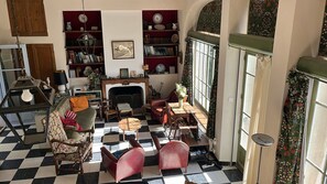 A traditional living room with a fireplace, checkered floor, and a large window with curtains. - Beautiful Provencal house, 6 bedrooms, Tennis - At the foot of Mont Ventoux (Saint-Hippolyte-le-Graveyron)