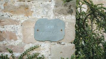 Eine Steinsäule mit einem Schild, auf dem 'SUN COTTAGE' steht.
