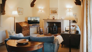 A cozy living room with a fireplace, a television, and a sofa. - Traditional Cottage Near Richmond Yorkshire Dales (Richmond)