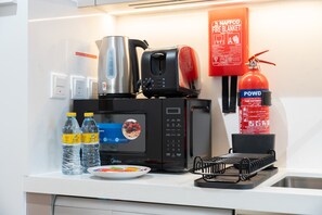 Eine Küche mit Mikrowelle, Toaster, Wasserkocher und Feuerlöscher.