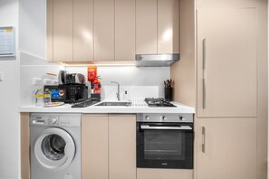 Eine moderne Küche mit Waschmaschine, Backofen und Mikrowelle.