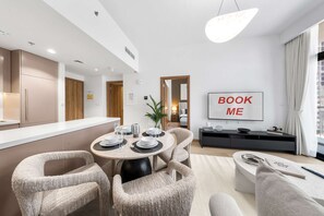 Ein modernes Wohnzimmer mit Essbereich, Flachbildfernseher und einer Couch.