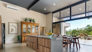 Una cucina moderna con una grande isola, mobili in legno e vista sull'esterno.