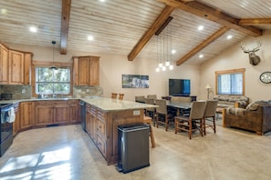 A spacious kitchen with wooden cabinets, a granite countertop, and a built-in refrigerator. - 3 Units at Getaway Lodges! West Yellowstone Base (Island Park)