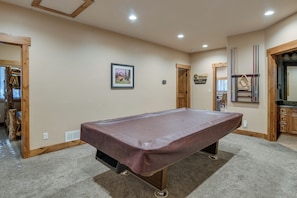 A pool table in a room with a carpeted floor, wooden walls, and recessed ceiling lights. - 3 Units at Getaway Lodges! West Yellowstone Base (Island Park)