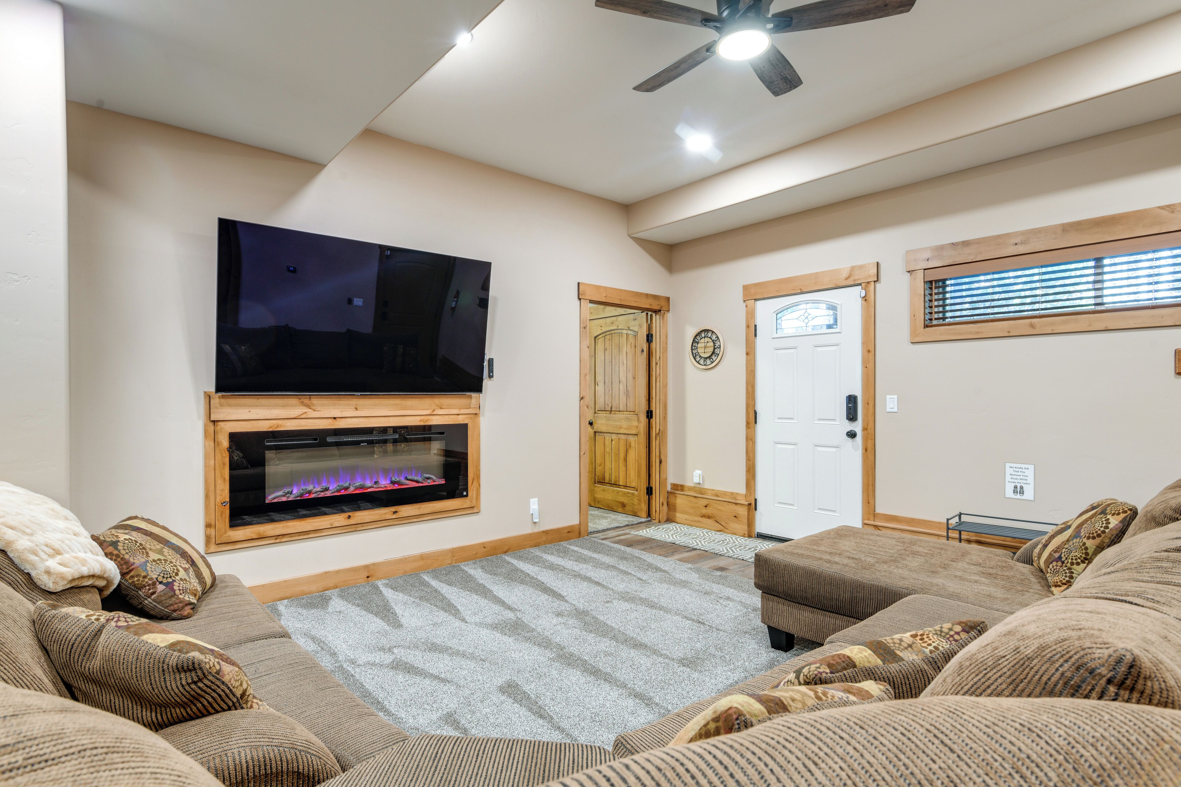 Una sala de estar con chimenea, televisor y ventilador de techo.