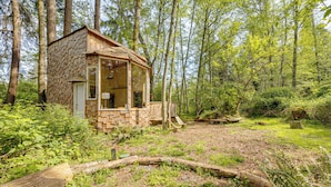 A small wooden cabin surrounded by dense forest. - Whidbey Island Tiny Home Near Trails & Beaches! (Oak Harbor)