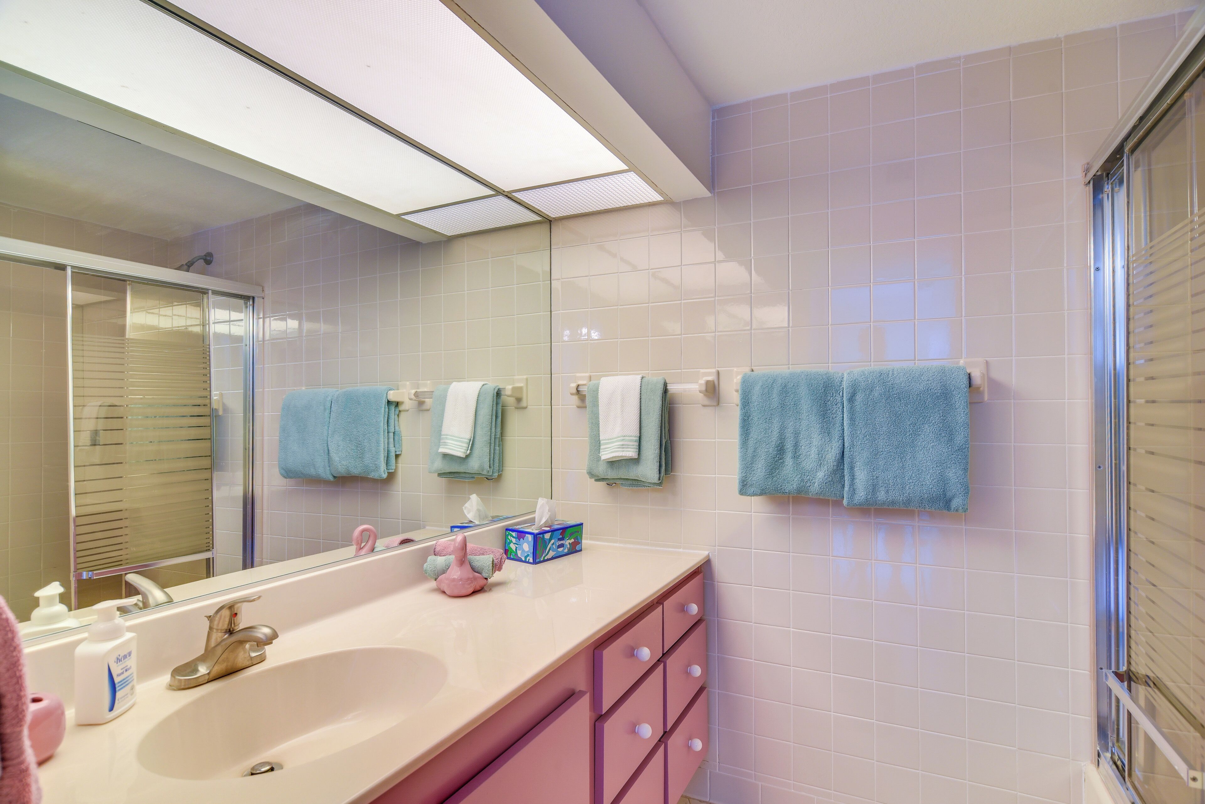 Une salle de bain avec un lavabo, un miroir et des serviettes.