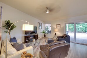 A modern living room with a sofa, a coffee table, a TV, and a fireplace. - Golf, Swim, Play & Relax! Gated Sun Lakes Home (Chandler)