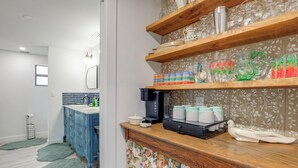 A bathroom with a blue vanity, a wooden shelf with glassware, and a patterned curtain. - 2 Mi to St Lucie Access! Stuart Getaway w/ Patio (Stuart)
