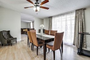 A dining area with a wooden table, chairs, a ceiling fan, and a treadmill. - Family Friendly! Rural El Paso Home: Patio & Grill (El Paso)