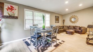 A dining area with a round table and chairs, a sofa, and a decorative mirror.