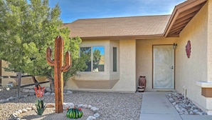 A house with a stucco exterior, a front door with a decorative glass panel, and a cactus in the front yard. - Fenced Yards! Quiet 2-unit Combo in Tucson (Tucson)