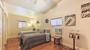 A bedroom with two beds, a ceiling fan, and wall decorations including a popcorn sign and a ticket sign. - Fenced Yards! Quiet 2-unit Combo in Tucson (Tucson)