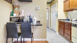 A kitchen with a microwave, toaster, kettle, and wooden cabinets. - Walkable Retreat Near The Island! Gateway to Gsmnp (Pigeon Forge)