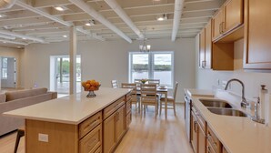 Une cuisine moderne avec des meubles en bois, un îlot central et un coin repas avec des chaises.