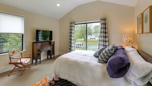 A bedroom with a bed, a television, a desk, a chair, and a window with a view of the outside. - Potomac Riverfront! Home Near St Clements Island (Coltons Point)
