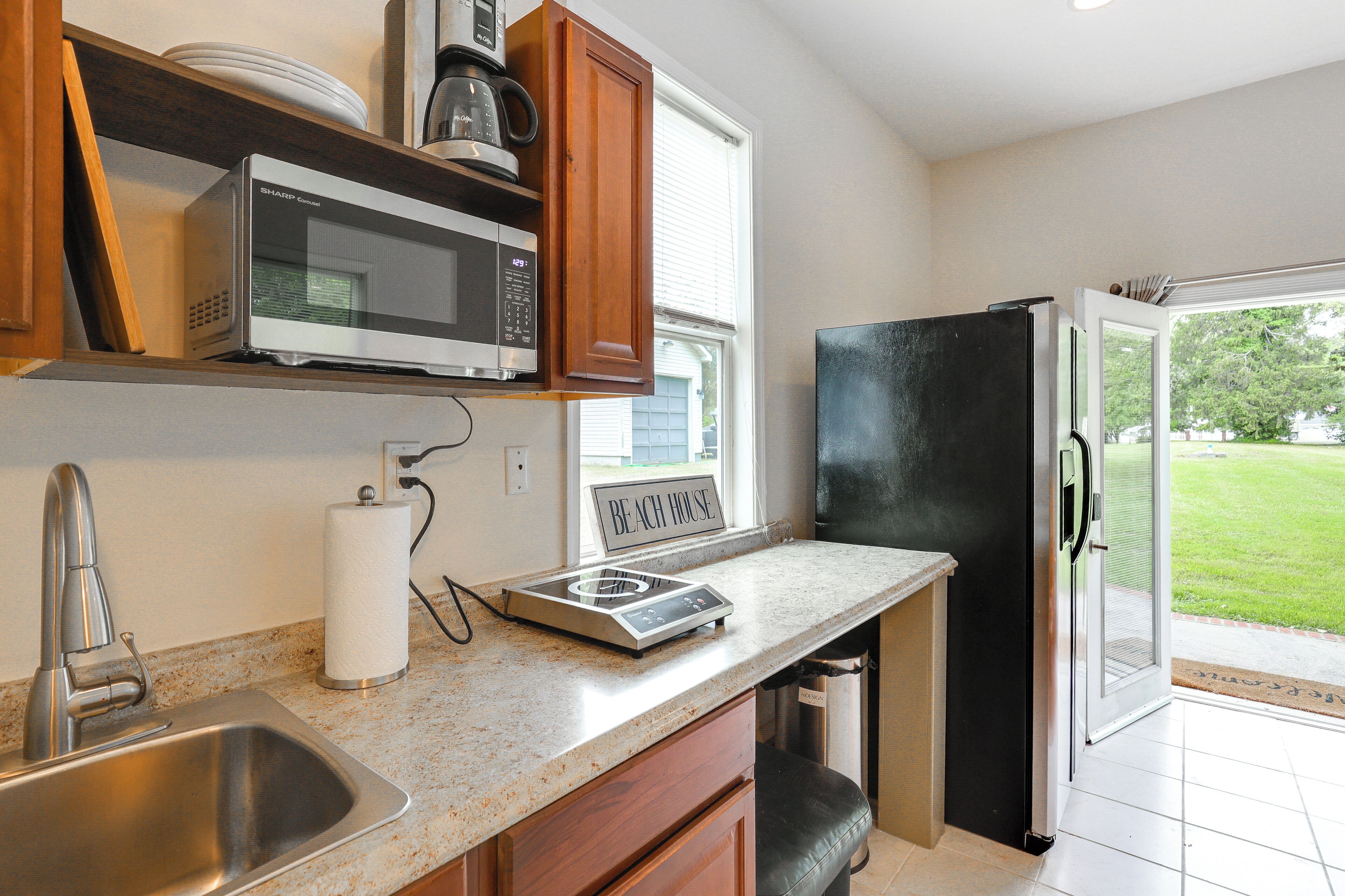 A kitchen with a stainless steel sink, a microwave, a toaster, and a refrigerator.