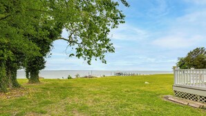 A grassy area with a dock extending into a body of water, surrounded by trees. - Potomac Riverfront! Home Near St Clements Island (Coltons Point)