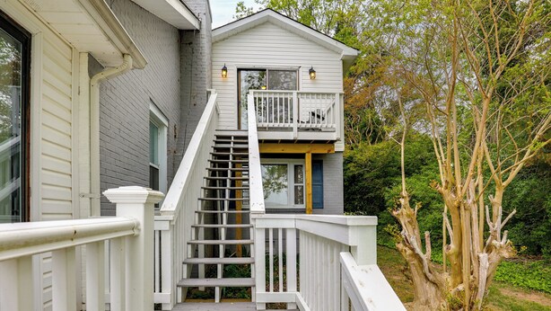 A two-story house with a wooden staircase leading to a balcony. - Potomac Riverfront! Home Near St Clements Island (Coltons Point)