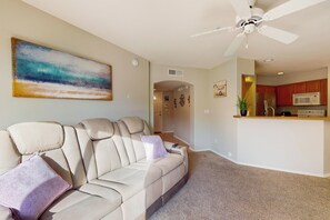 A living room with a beige sofa, a ceiling fan, and a painting on the wall. - 2BR Condo in Fountain Hills w/ Mountain Views (Fountain Hills)