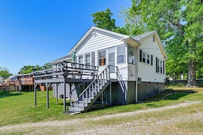Ein eingeschossiges Haus mit überdachter Veranda und einer Treppe zum Eingang.