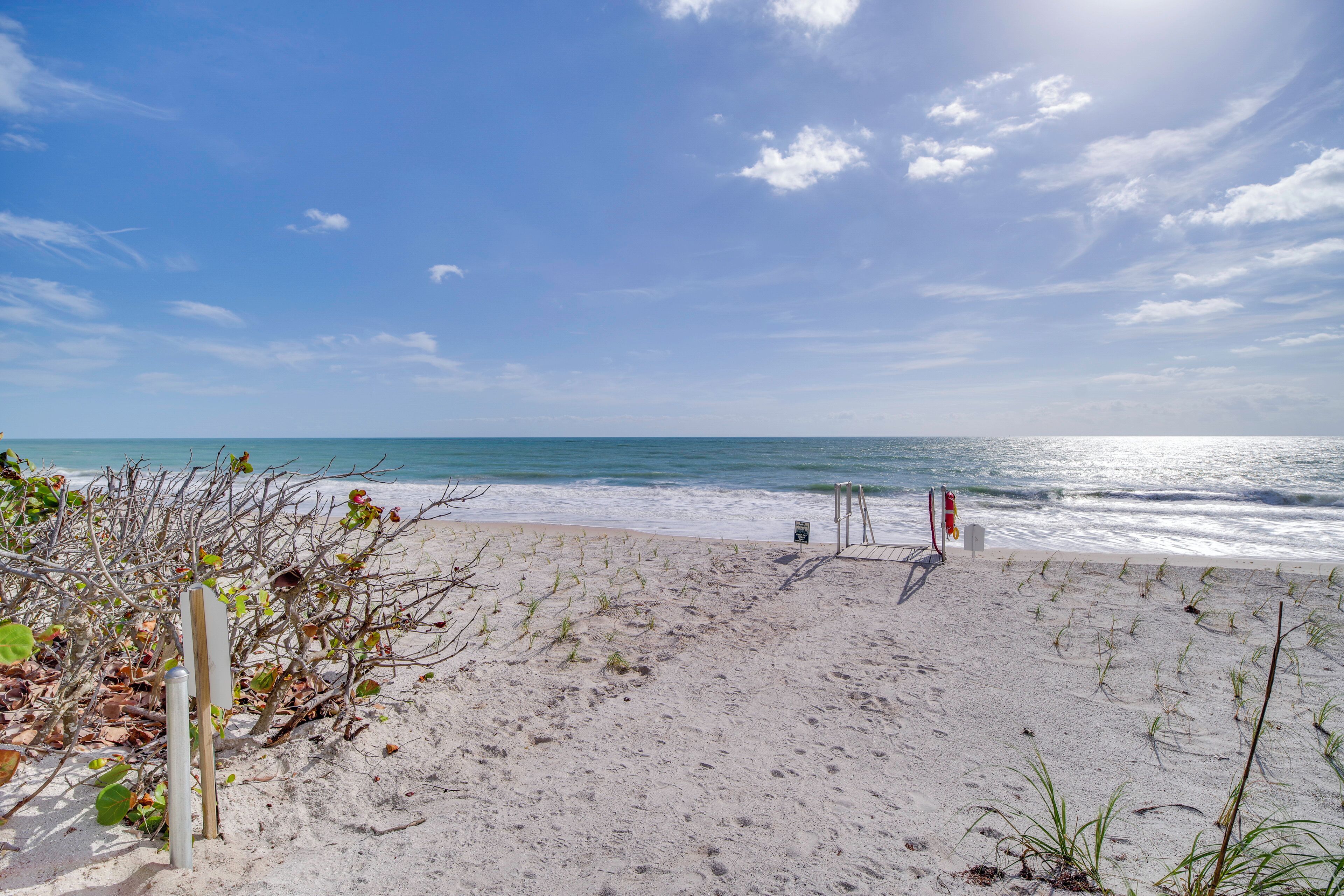 A sandy beach with a clear sky and ocean.