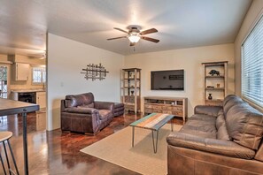 A spacious living room with a brown leather sofa, a coffee table, and a ceiling fan. - Groups Welcome! 2-home Tucson Escape w/ Fire Pit (Tucson)