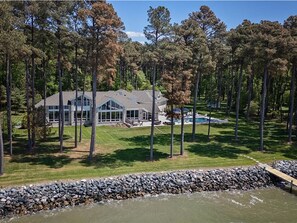 A large house with a swimming pool, surrounded by tall trees and a stone wall. - Bayview 2.0 | an ESVR property (Wittman)