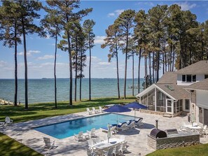A pool with lounge chairs, a barbecue grill, and a view of the ocean. - Bayview 2.0 | an ESVR property (Wittman)
