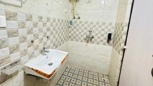 Een badkamer met een witte wastafel, douche en toilet.