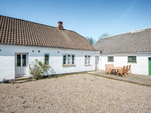 A white building with a tiled roof and a gravel courtyard. - 6 Person Holiday Home in Rodding (Rodding)