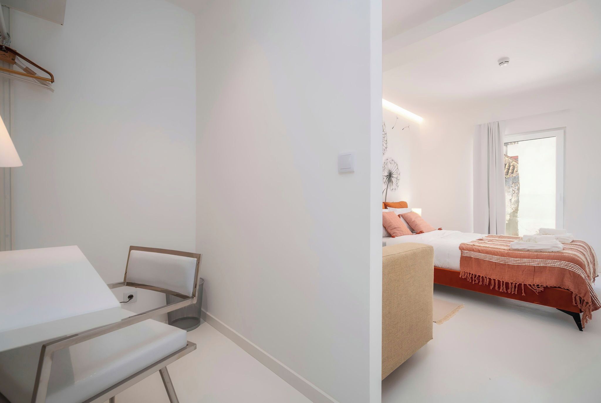 A modern bedroom with a bed, bedside table, and a chair.