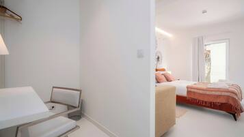 A modern bedroom with a bed, bedside table, and a chair.