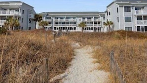 Ein Hotel direkt am Strand mit einem Sandweg zum Eingang.