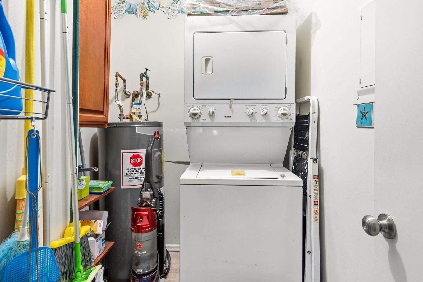 A compact laundry room with a washer and dryer, a water heater, and cleaning supplies.