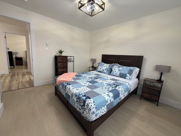 A bedroom with a bed, bedside tables, a dresser, and a ceiling light fixture. - Water View and 15 minutes away from most popular attractions. (Trinity Bay North)